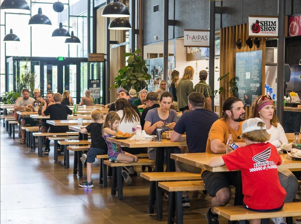 Families eating at long tables in Market Hall.