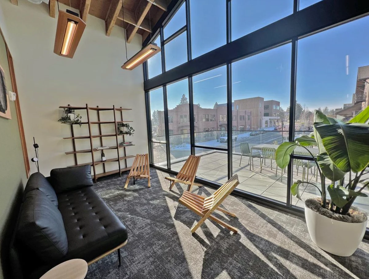 A sunny lounge with a leather sofa and lounge chairs.